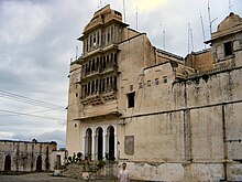 Monsoon palace entrance against backdrop of cloudy skies