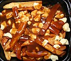 "Poutine", e bekannt Iessen aus dem Québec (Fritte mat Kéis a bronger Zooss)