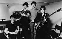 Photo en noir et blanc des Talking Heads (de gauche à droite : Chris Frantz, Jerry Harrison, David Byrne, et Tina Weymouth).