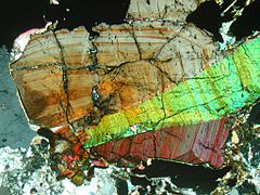 Зональный кристалл касситерита в шлифе (поляризованный свет, ширина изображения — 3,3 мм)