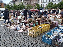 Photographie d'une place à la fin d'un marché.