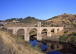 En arco (puente de Alc�ntara), trabaja a compresi�n en la mayor parte de la estructura. Usado desde la Antig�edad.