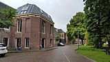 De 'binnenzijde' van het gebouw langs de Kattenburgerstraat, met rechts het 'Marinepark' met hoge bomen; 2016.