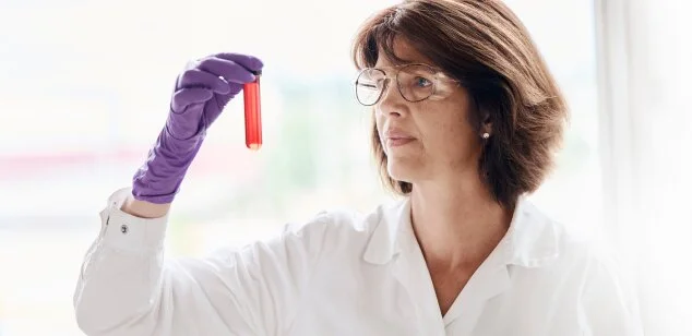 Laboratory researcher is holding and observing a sample.