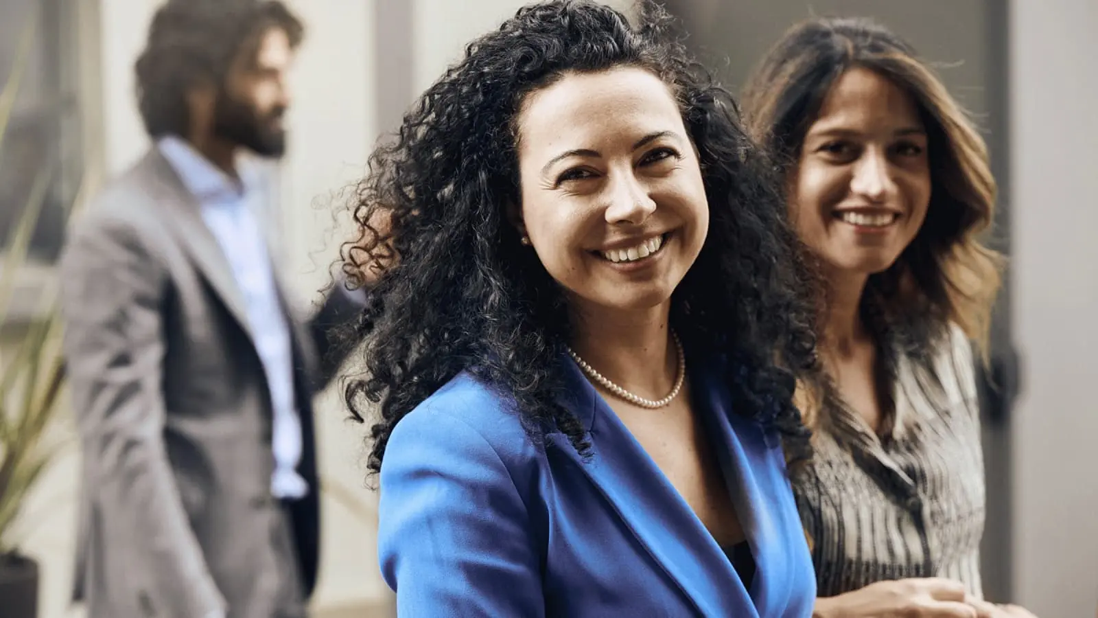 Woman in focus smiling and looking into the camera