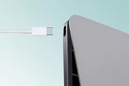 USB-C cable approaching a USB-C port on a laptop.